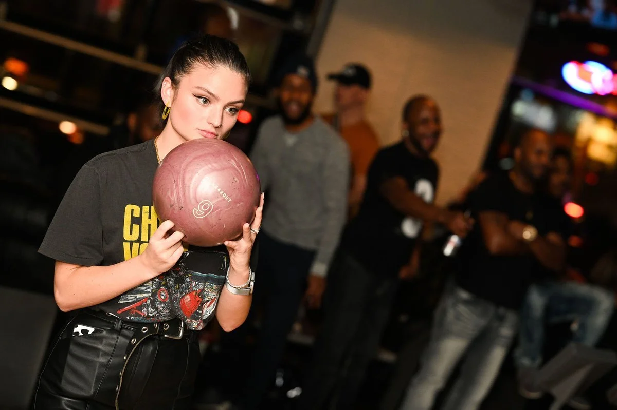 Une joueuse tient une boule devant une allée de The Ballroom Bowl — John Street, à Toronto.